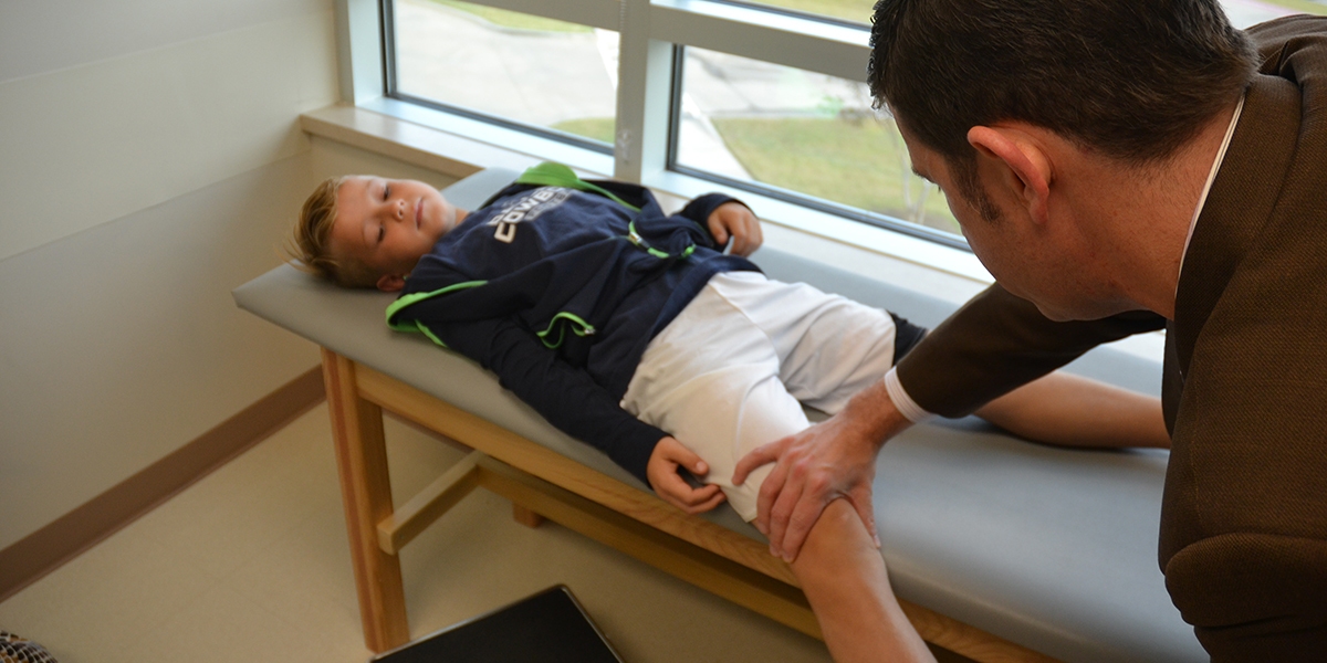 OCD-of-the-knee Dr. Ellis evaluating a patient's knee in clinic.