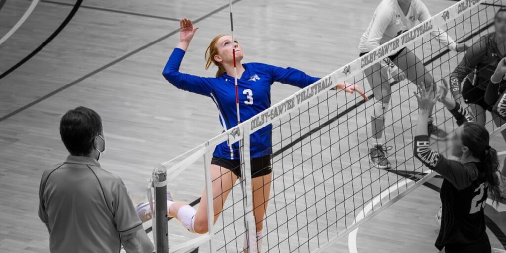 Former patient Kamryn spikes a ball over the volleyball net during a game.