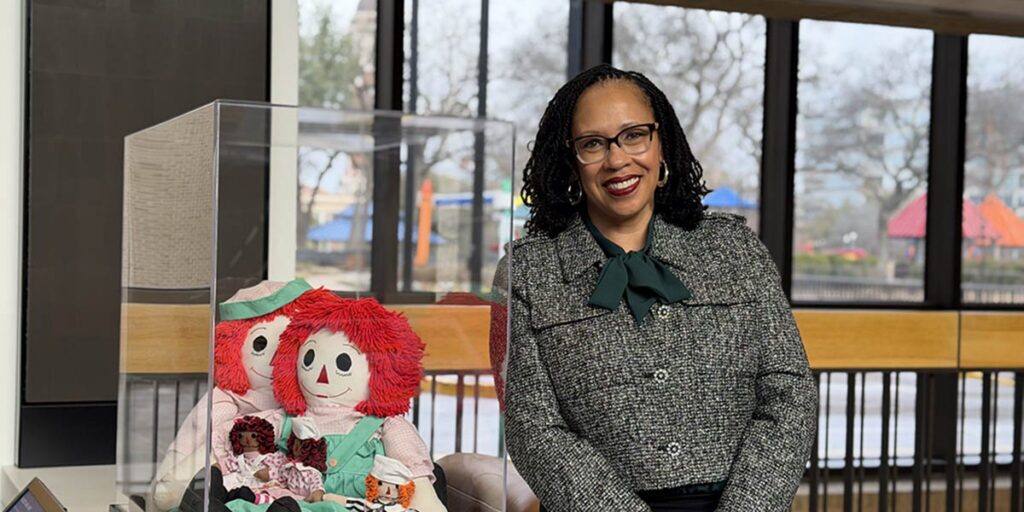 Frazet Lankford next to a display of Raggedy Ann dolls in Scottish Rite.