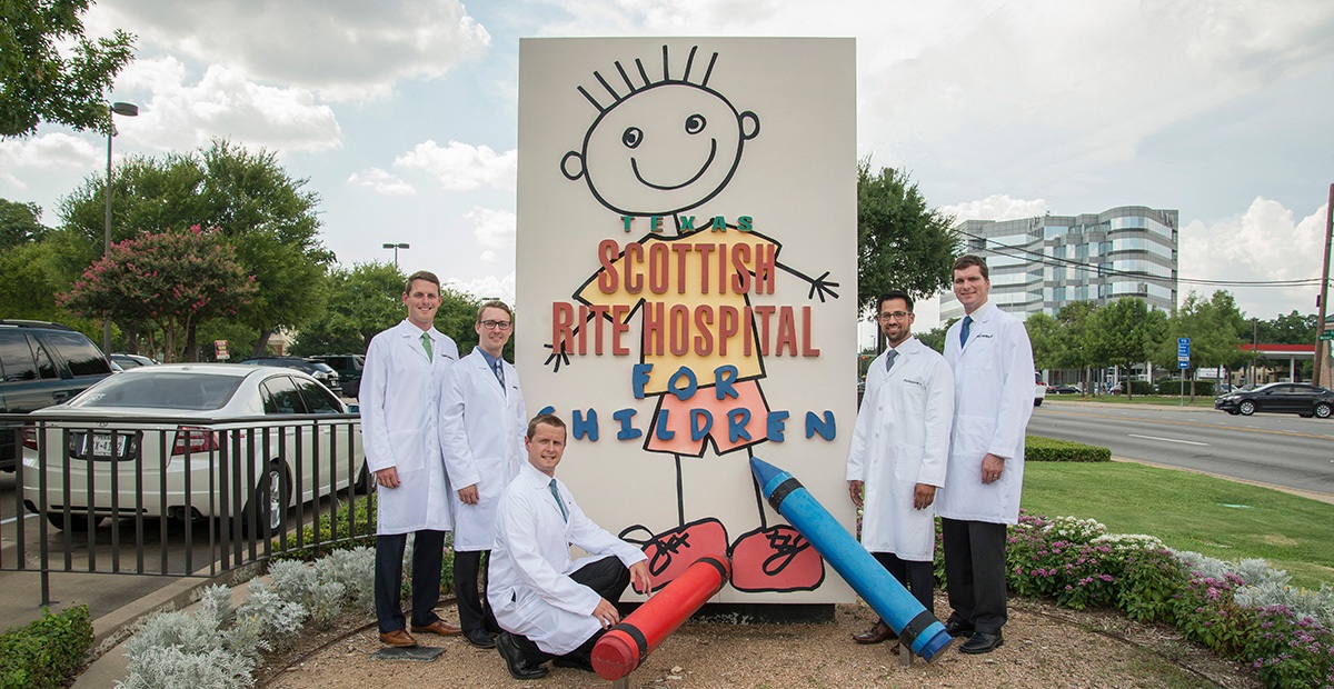 Fellows around hospital signage.