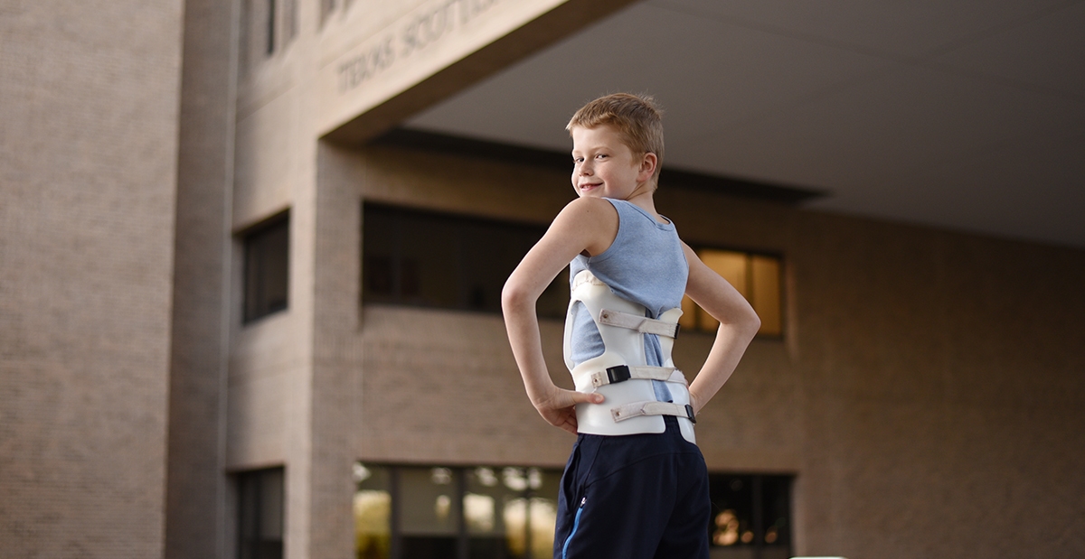 scoliosis child in brace outside hospital
