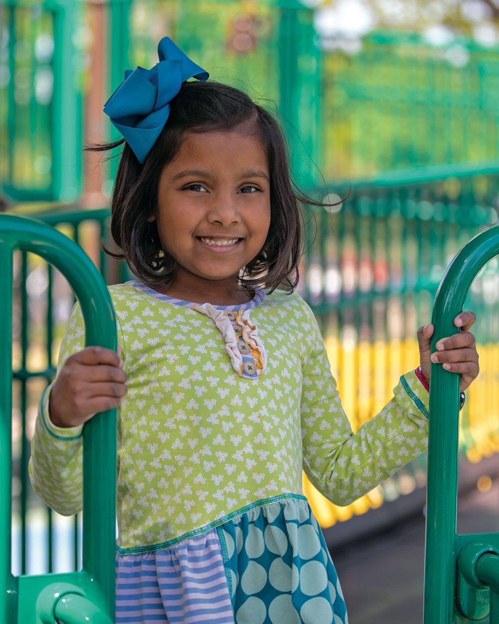 clinical-care-mod1 A young girl stands on a playground smiling at the camera.