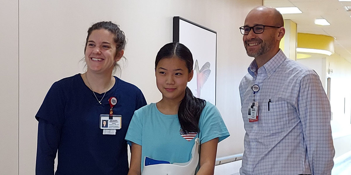Danielle smiles for a picture with Assistant Chief of Staff Brandon A. Ramo and Orthotist and Prosthetist Manager Kelsey Thompson, C.P.O., L.P.O.